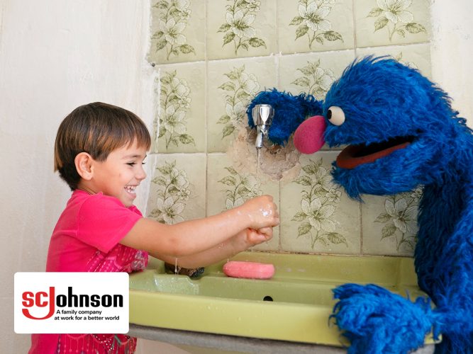 Grover and a child washing hands.
