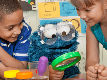 Cookie Monster and kids with a magnifying glass