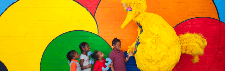 Big Bird greeting a group of kids.
