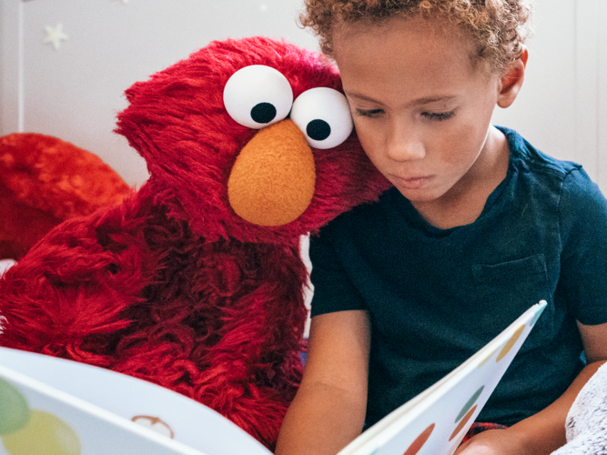 Elmo and a child reading.